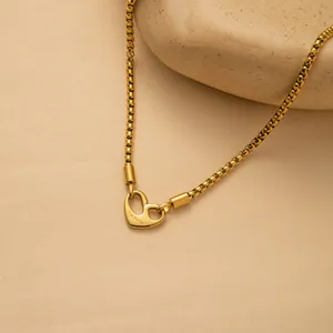 Macro detail of gold box chain necklace featuring a heart clasp engraved with I Am Worthy