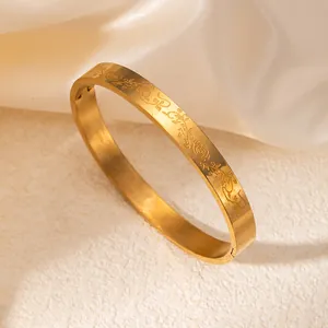 Detalle del patrón de rosa grabado con láser en el brazalete de acero dorado pulido