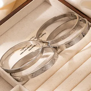 Lot de quatre bracelets en acier 18k texturés avec motifs à carreaux et fleurs