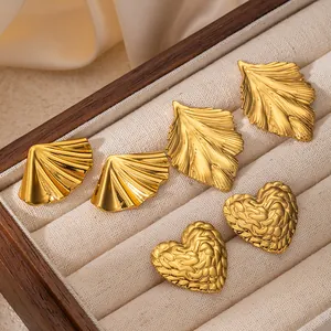 Tre paia di orecchini in acciaio dorato a forma di foglia e cuore in una scatola regalo