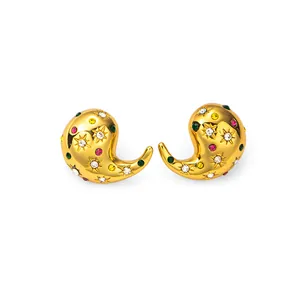Détail de boucles d'oreilles goutte dorées avec zircons colorés et gravure d'étoile