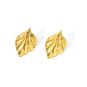 Détails de boucles d'oreilles dorées en forme de feuilles avec textures de nervures délicates