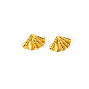 Détail des boucles d'oreilles feuilles dorées montrant la texture radiale et le métal poli