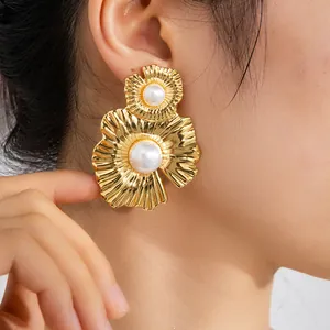 Détail de boucles d'oreilles tournesol en or 18K avec doubles pétales et perles blanches