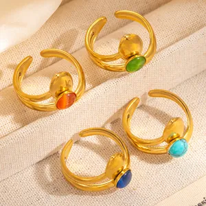 Detail view of four gold-plated adjustable rings with colorful round cabochon stones