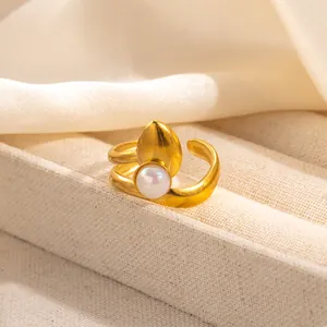 Detail of adjustable gold ring with white pearl and teardrop shape on fiber texture