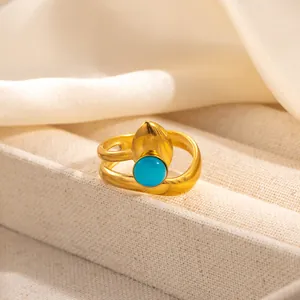 Macro shot of gold adjustable ring featuring a blue round gemstone and vintage metal leaf detail