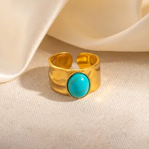 Macro detail van vergulde gehamerde ring met een ovale turquoise edelsteen inleg