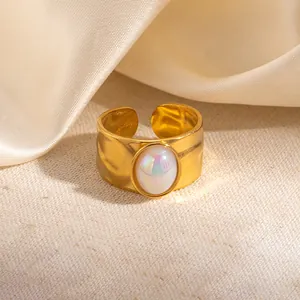 Detail van een gouden verstelbare ring met lavatextuur en ovale iriserende opaalsteen