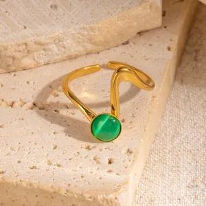 Dettaglio macro dell'anello a onde in oro 18k con gemma occhio di gatto verde tonda