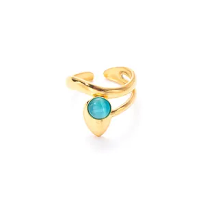 Detail of a gold curved open ring featuring a vibrant blue cat eye stone inlay