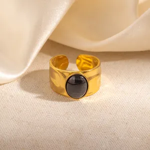 Detailopname van een goud gehamerde roestvrijstalen ring met zwarte ovale edelsteen