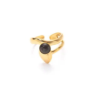 Detailed shot of adjustable gold open ring with matte finish and black round gemstone