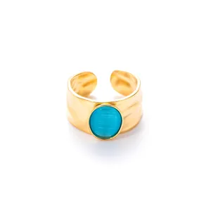 Detailweergave van de goudkleurige ring met gehamerde textuur en blauwe opaalsteen
