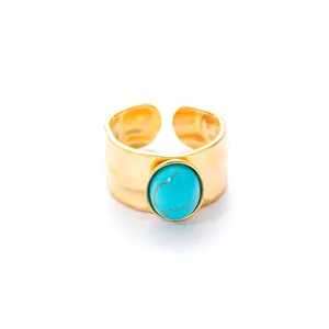 Macro-opname van een brede goudkleurige ring met reliëfstructuur en blauwe turquoise steen