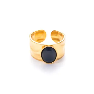 Detail van verstelbare gouden ring met zwarte kattenoogsteen en gehamerde textuurafwerking
