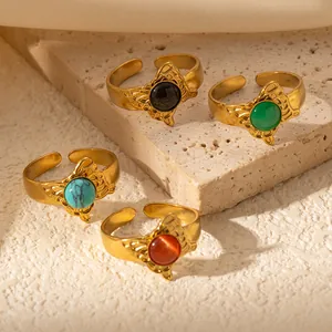 Dettaglio di quattro anelli regolabili vintage con pietre colorate su superficie in pietra