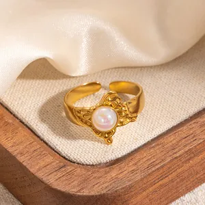 Dettaglio anello vintage a farfalla dorato con intarsio in perla e fascia regolabile
