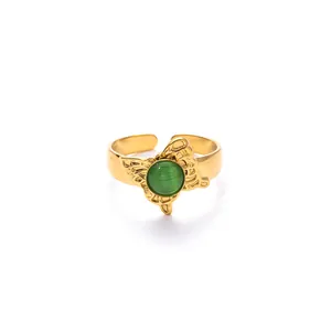 Vista dettagliata di un anello regolabile dorato con pietra occhio di gatto verde e ali di farfalla