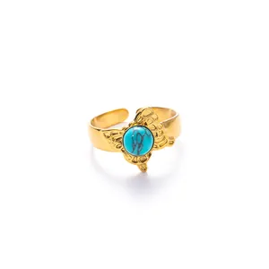 Dettaglio anello regolabile in oro con pietra turchese e ali di farfalla retrò
