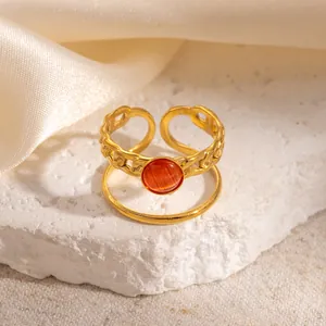 Close-up of dual-layer gold-plated ring with reddish-brown cat eye stone on stone base