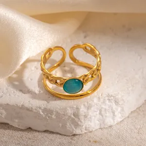 Detail of adjustable 18k gold plated ring with Cuban chain link and blue cat eye stone
