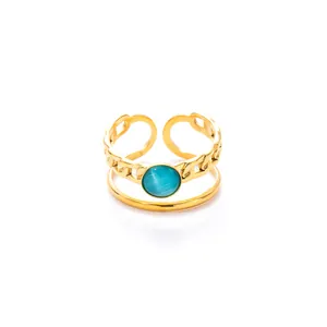 Detail of a dual-layer adjustable gold ring with a blue cat-eye stone and chain design