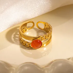 Dettaglio dell'anello a doppio strato placcato oro con gemma arancione e catena