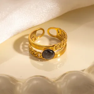 Vista dettagliata di un anello a catena vintage dorato con pietra occhio di gatto grigia