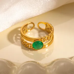 Dettaglio anello dorato regolabile con gemma verde e design a catena a strati