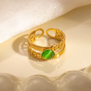 Dettaglio macro di anello regolabile dorato con pietra occhio di gatto verde e catena