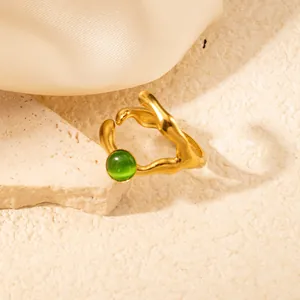 Dettaglio anello dorato irregolare a Y con pietra occhio di gatto verde su pietra