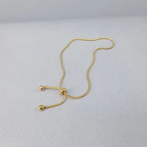 Dettaglio di un bracciale a catena a serpente dorata con chiusura regolabile