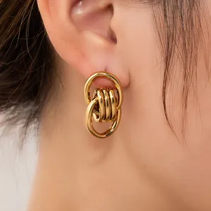 Close-up of interlocking gold-plated hoop earrings featuring a vintage knot design