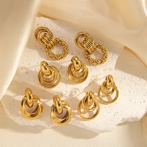 Close-up of assorted 18k gold plated chunky hoop earrings on white stone and silk