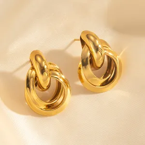 Detailed view of intertwined 18k gold-plated hoop earrings on a soft silk background
