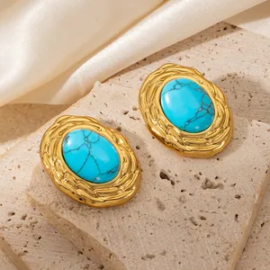 Detail of 18K gold plated earrings featuring oval turquoise stones and braided texture