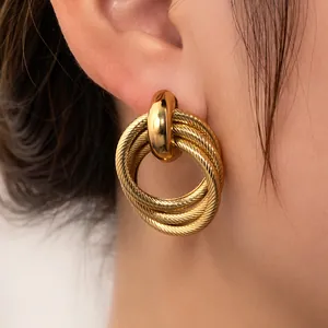 Nahaufnahme goldener, mehrlagiger Creolen mit Spiralstruktur für einen Vintage-Look