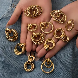 Set aus Retro-Creolen aus Titanstahl in Gold mit hohlem Design auf blauem Denim-Stoff