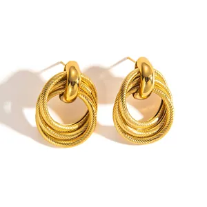 Detailaufnahme der goldfarbenen Titanohrringe mit mehrlagigen Ringen in Seiloptik