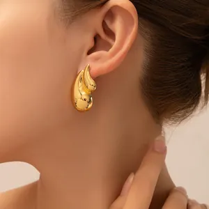 Nahaufnahme eleganter goldener Tropfenohrringe mit hochglanzpoliertem Finish