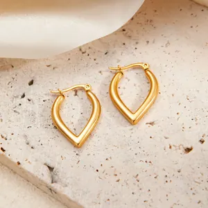 Dettaglio degli orecchini a goccia in oro a forma di V su pietra e seta
