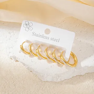 Close-up of three pairs of gold stainless steel hoop earrings with tiny zircon stones