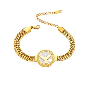 Détail du bracelet chaîne en acier doré avec pendentif colombe en nacre blanche