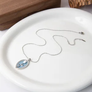 Detail view of a French vintage silver necklace with blue tulip oval pendant and bead trim
