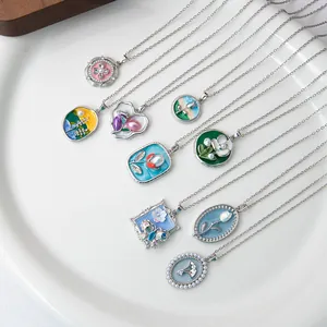 Flat lay of multiple French luxury pendant necklaces with floral and butterfly enamel charms