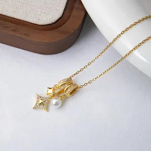 Detail of gold chain necklace with star pendants, zircon charms and round white pearl