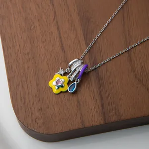 Detail of colorful enamel flower and heart charms on a silver link chain necklace
