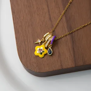 Detailed close-up of a gold chain necklace with colorful enamel charms and star pendants