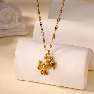 Close-up of golden crab pendant necklace with polished metallic finish and flat link chain